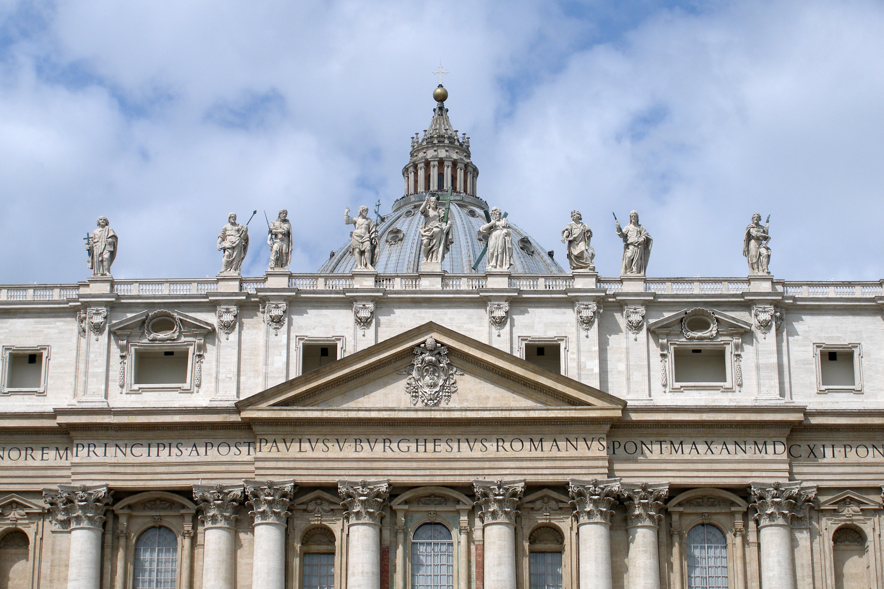 Imagem real/contextual: fachada da Basílica de São Pedro, sinal público do Vaticano como centro religioso, político e simbólico.